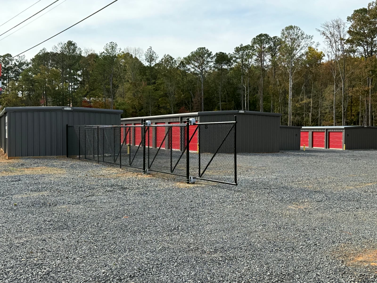 Black chain-link cantilever gate closing off self-storage units