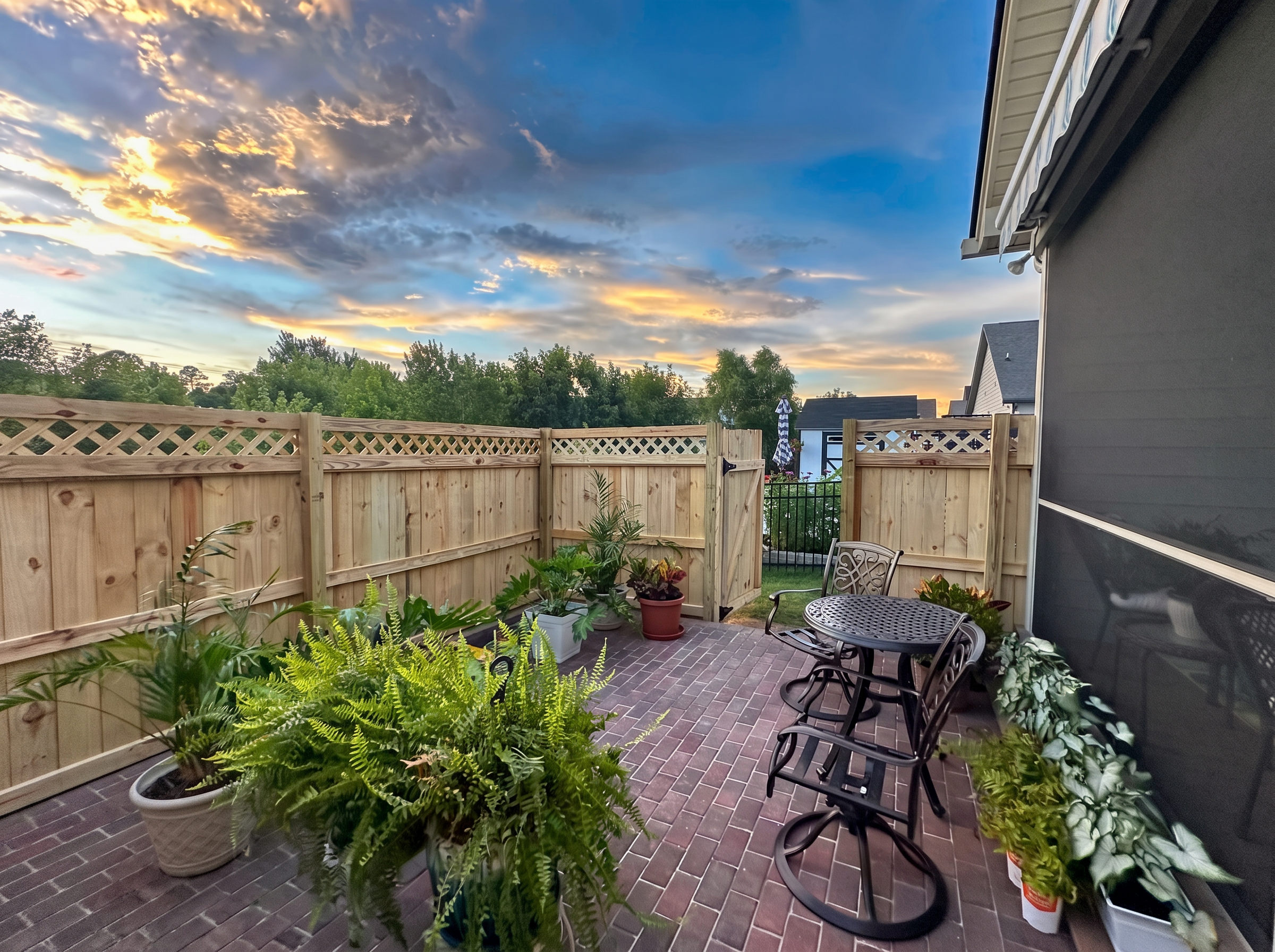 Lattice-top wood patio fence with an open walk gate