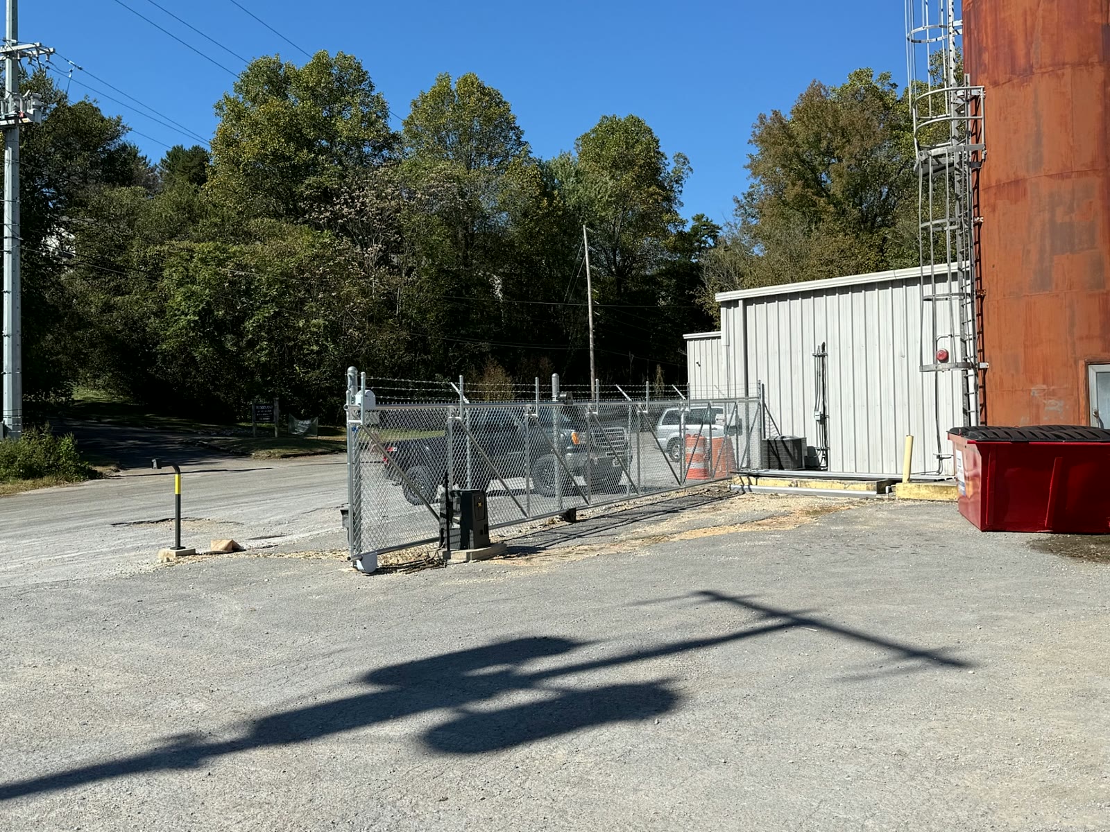 Galvanized cantilever slide gate with barbed wire at an industrial building