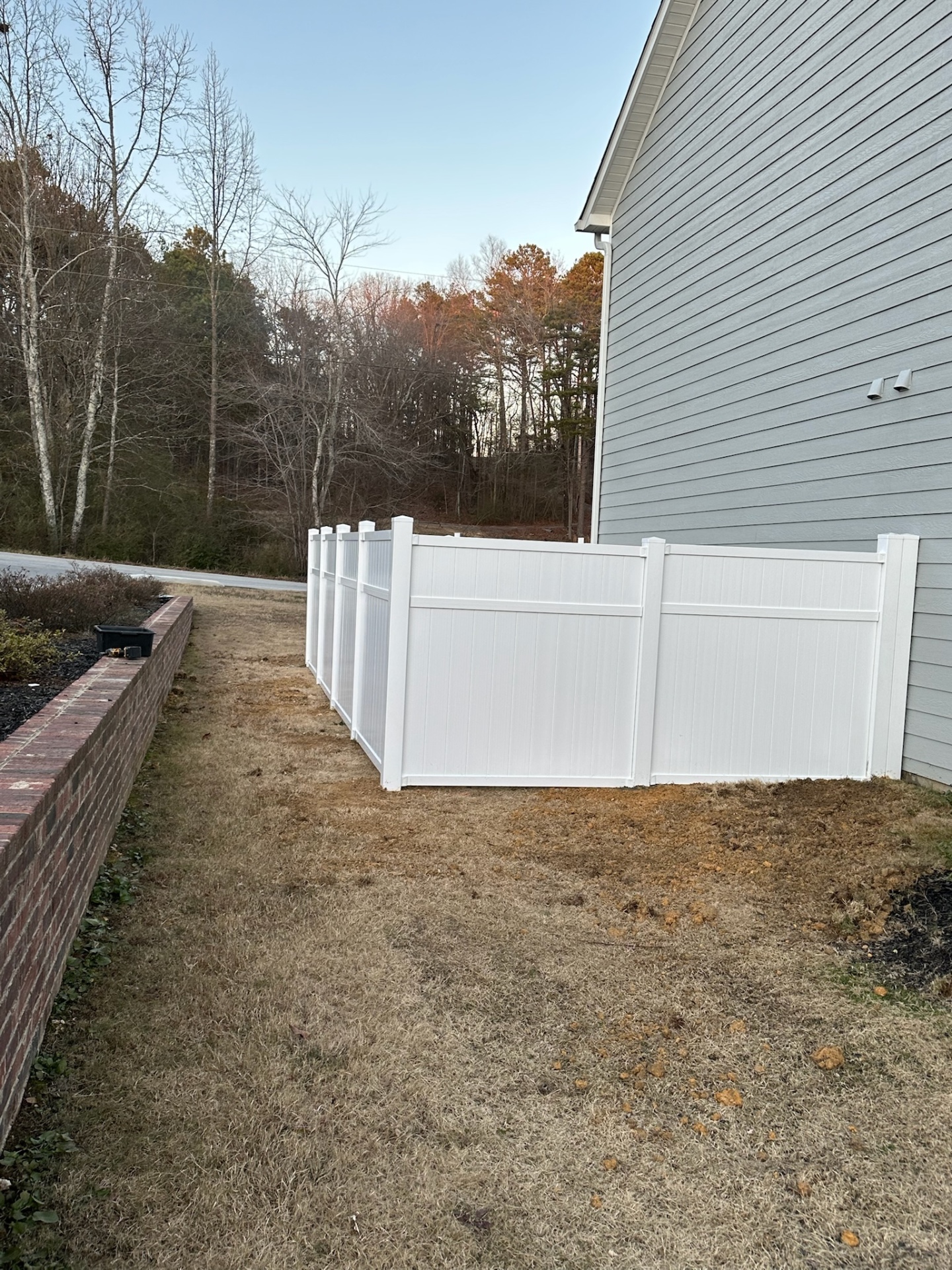 White vinyl privacy fence with clean panels around a residential yard