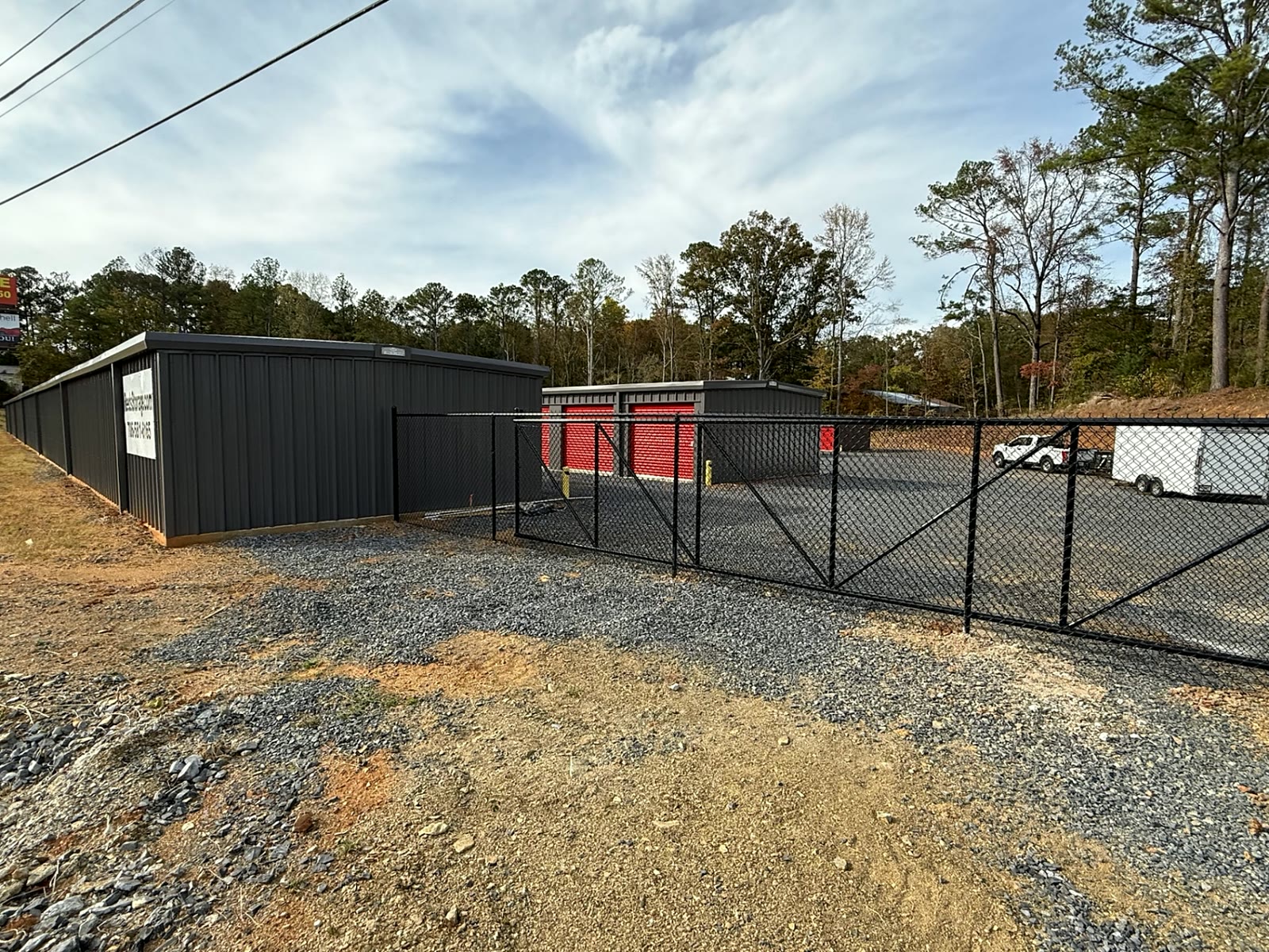 Black chain-link fence and slide gate at a self-storage facility