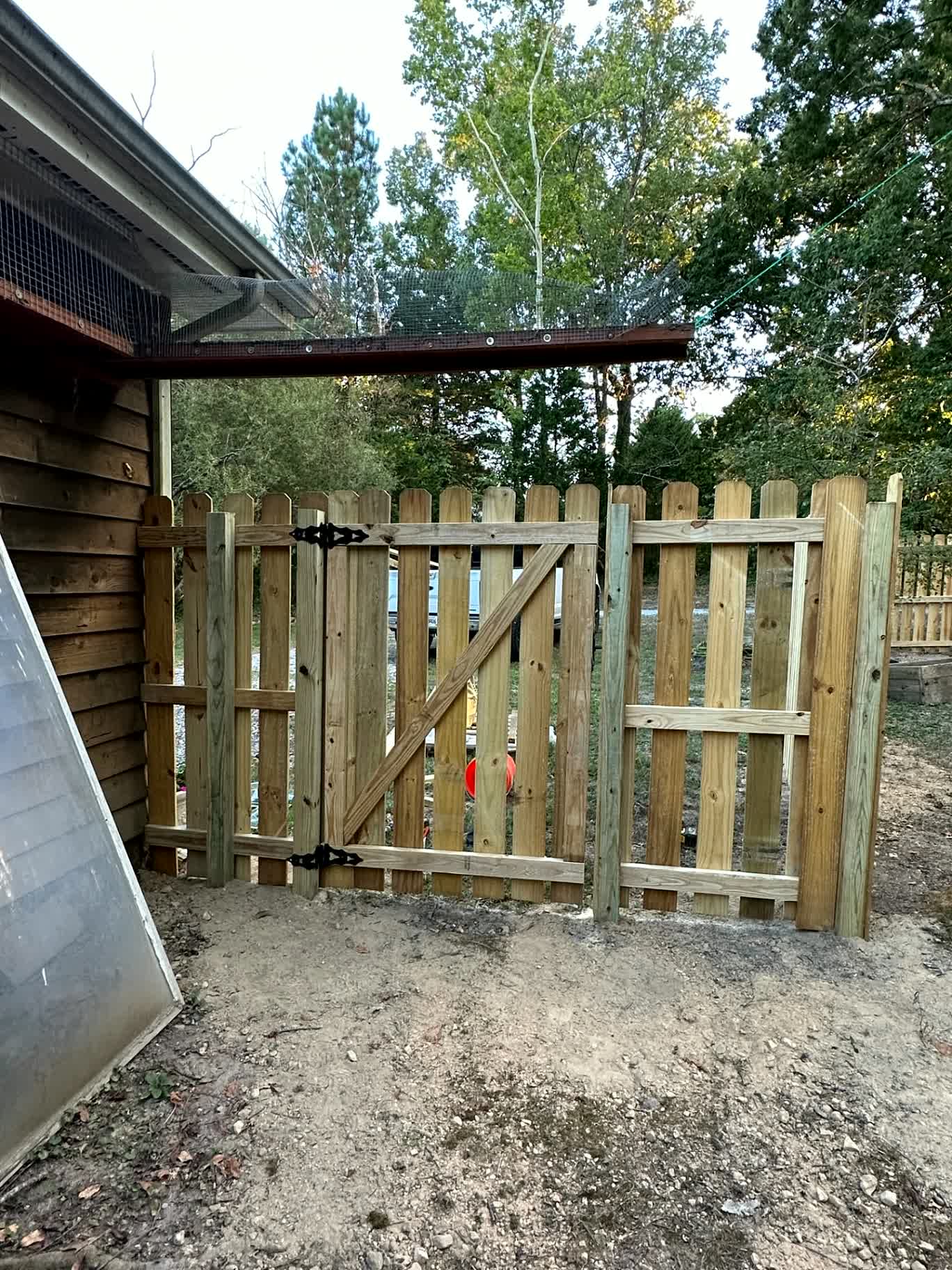 Wood picket double gate with diagonal bracing and black hardware