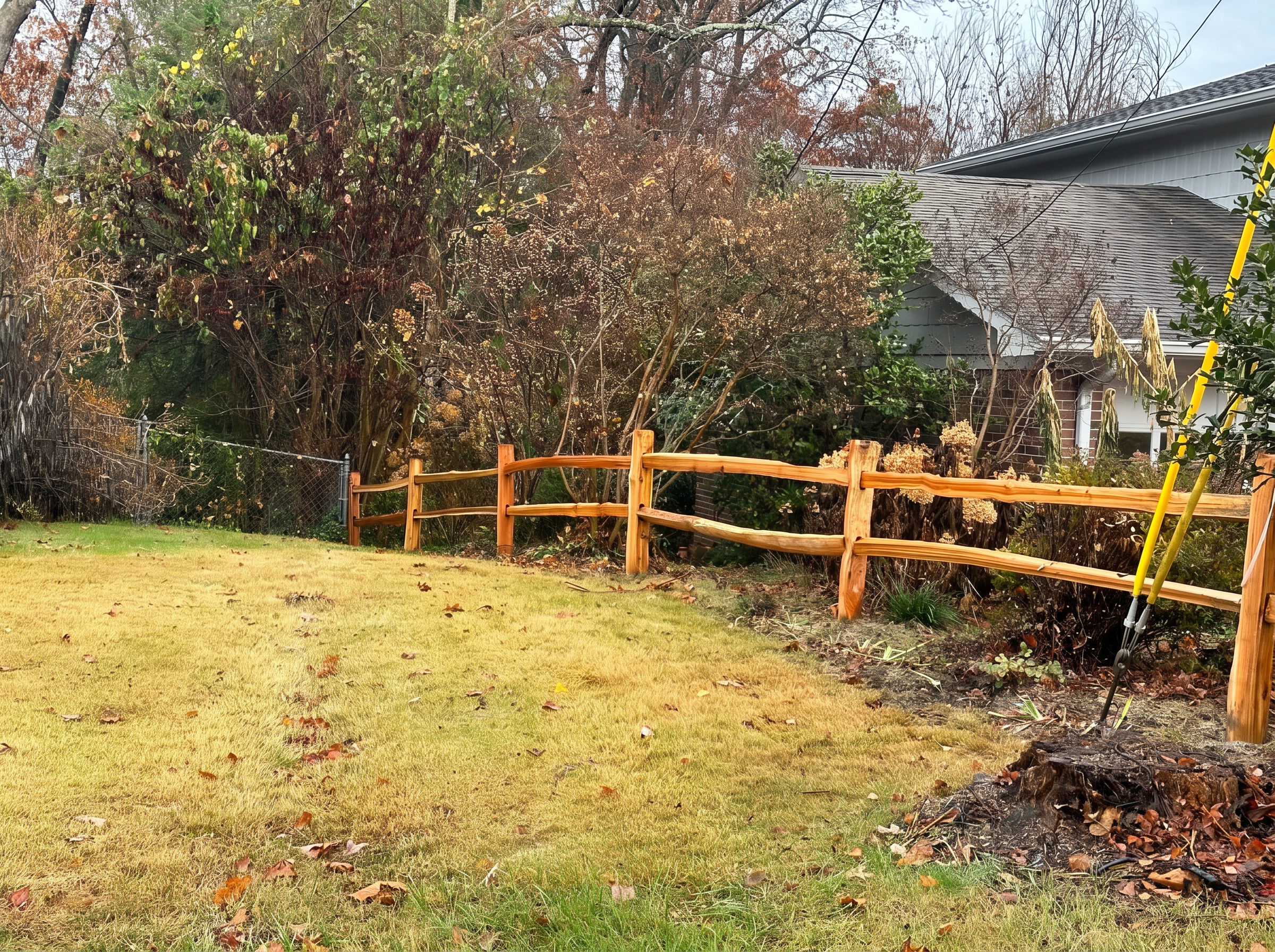 Rustic two-rail split rail fence along an autumn property boundary