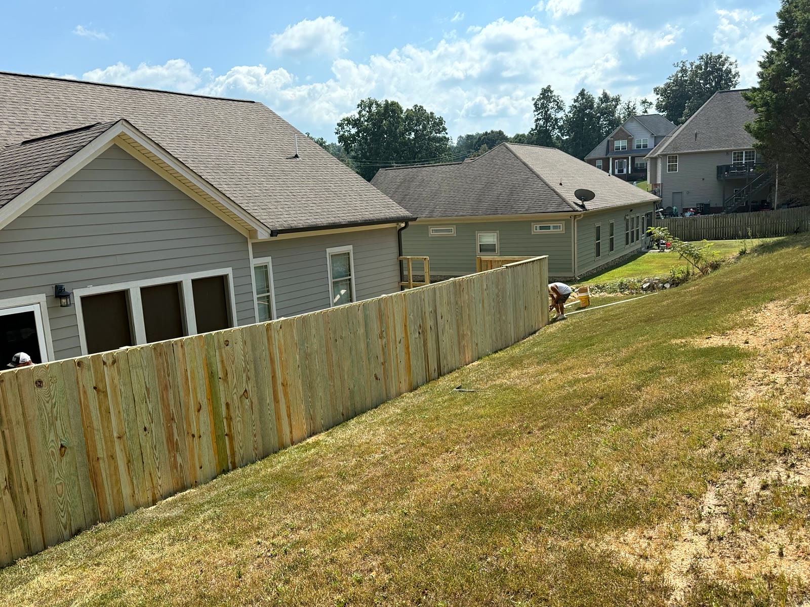 Dog-ear wood privacy fence following a hillside grade